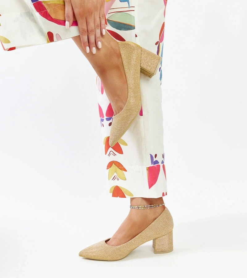 Złote świecące czółenka na słupku Laity